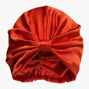 Tomato red organic silk hair bonnet flat lay on white background.