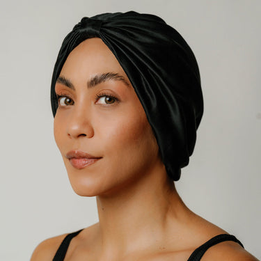 Black organic silk hair bonnet worn on model front view.