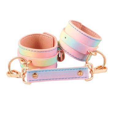 Pastel rainbow holographic PU leather wrist cuffs with rose gold hardware and spreader bar on white background.