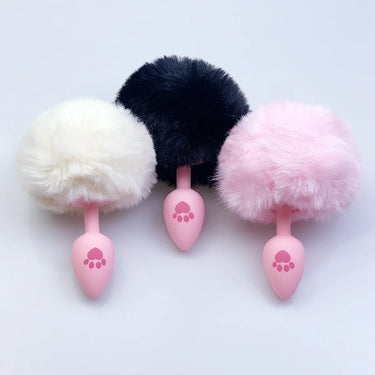 Pink silicone anal plugs with white and pink fluffy bunny tails close-up top view.