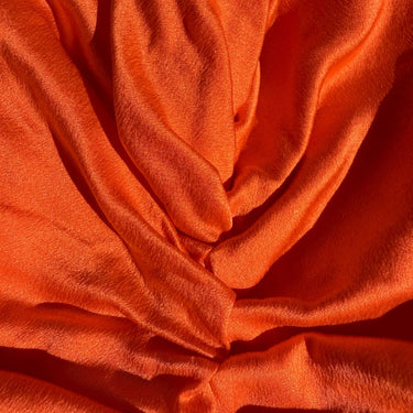 Tomato red organic silk hair bonnet close-up texture detail.