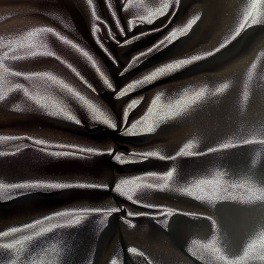 Black organic silk hair bonnet close-up texture detail.