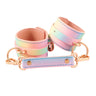 Pastel rainbow holographic PU leather wrist cuffs with rose gold hardware and spreader bar on white background.