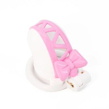 Angled view of pink bow chastity cage showing heart detail and sizing ring on white background.